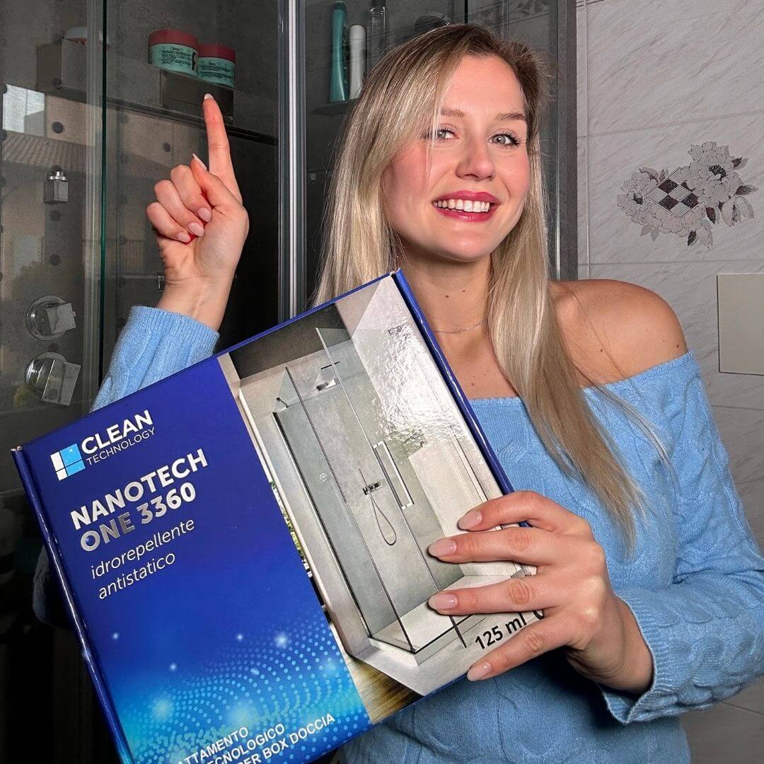 Donna sorridente mostra il trattamento nanotecnologico NANOTECHONE di cleantechnology per vetri del box doccia, idrorepellente e antistatico.
